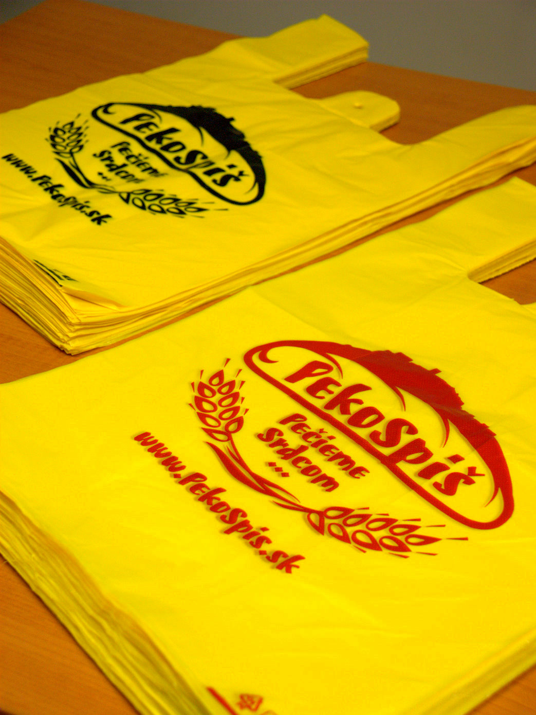 Žlté mikroténové tašky s rovnakou potlačou tlačené pol na pol rôznymi farbami