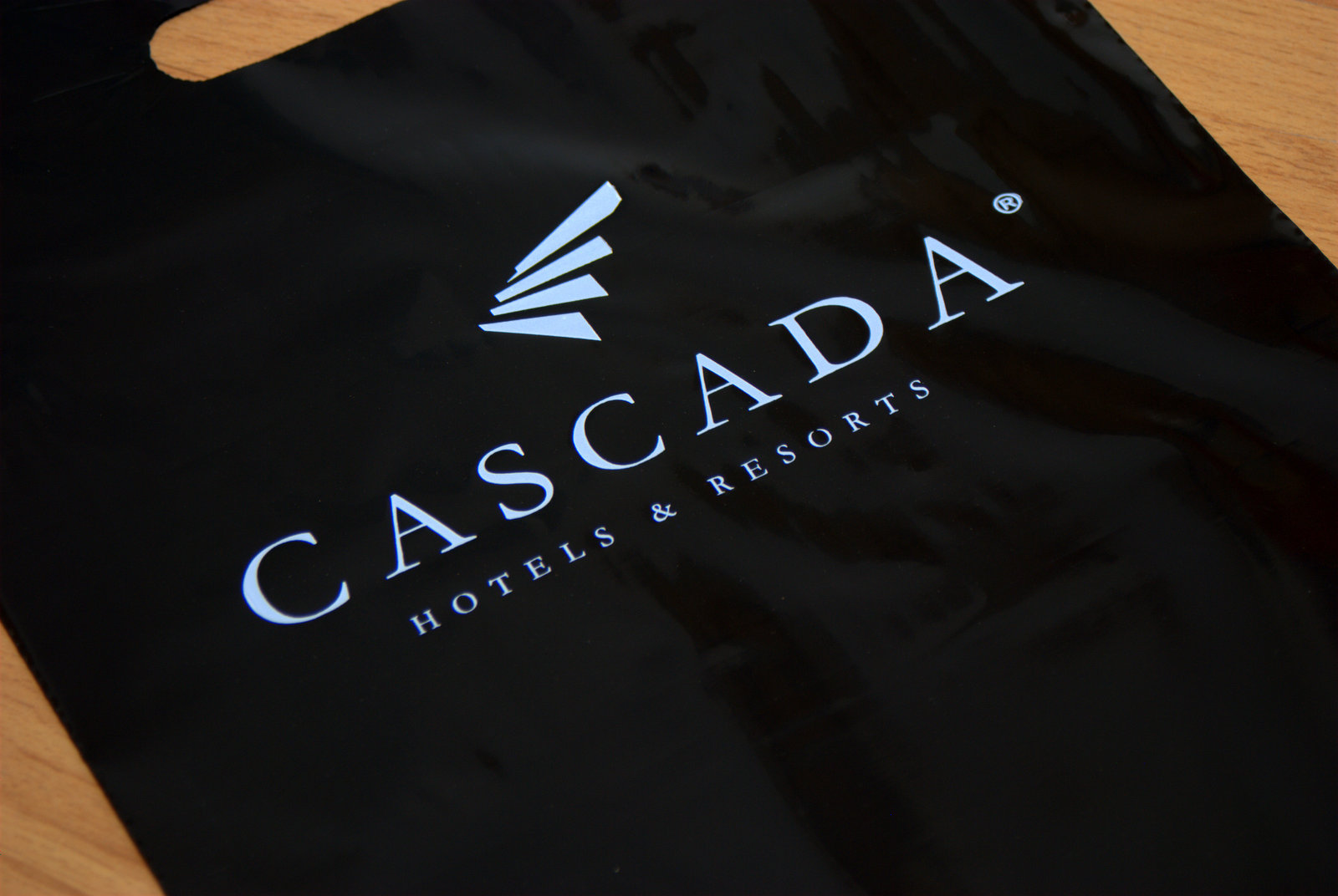 Čierna igelitová taška s bielou potlačou pre hotelový rezort Cascada