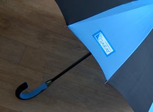 Farebná potlač loga firmy na modrom paneli dáždnika