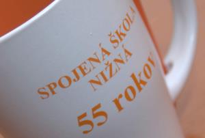 Detail oranžovej potlače na bielom hrnčeku